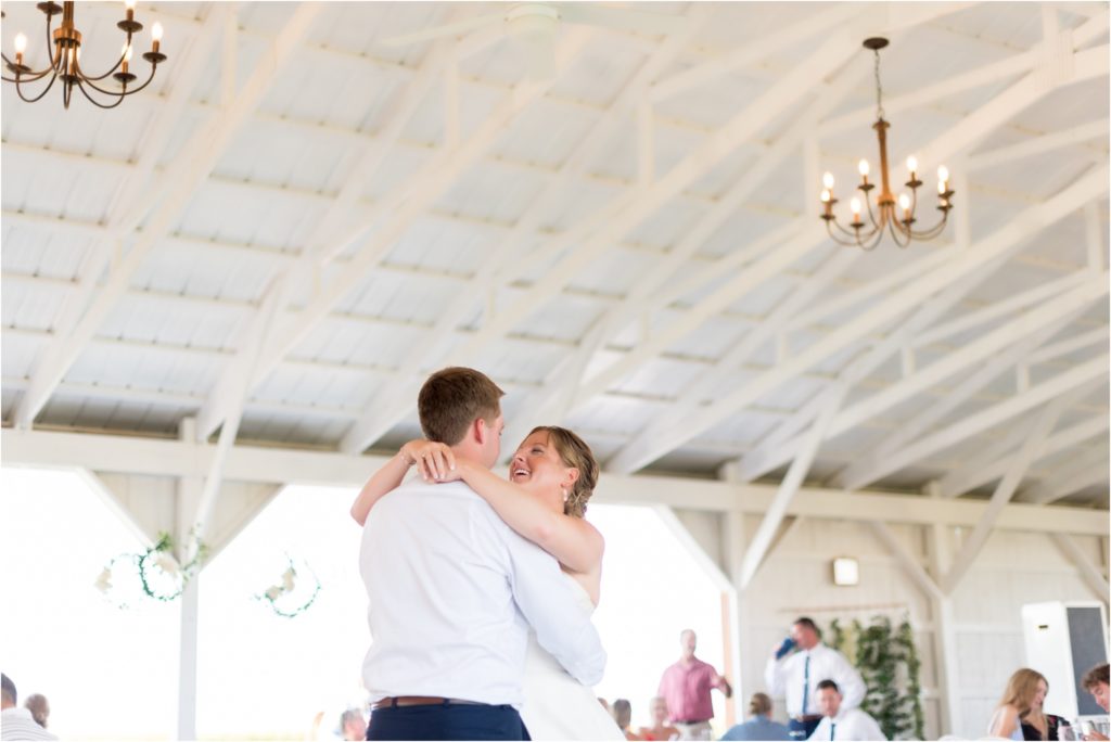 couple having a first dance in the beautiful white reception barn