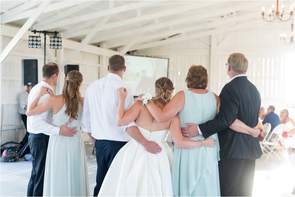 Bride watching a slideshow during the father daughter dance of her father that passed away