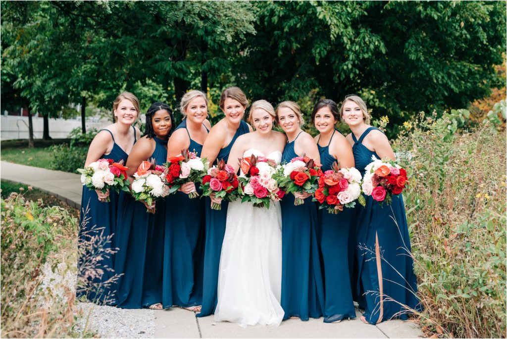 Navy blue bridesmaids dresses with stunning bouquets in red, pink and white.