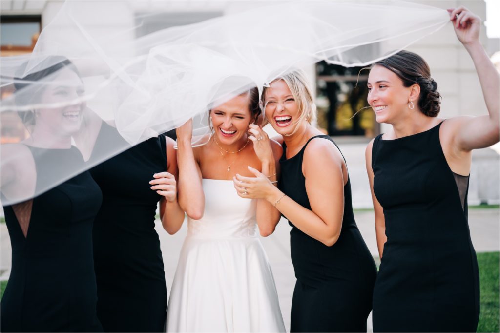 so windy the bridesmaids were laughing at the veil in the wind
